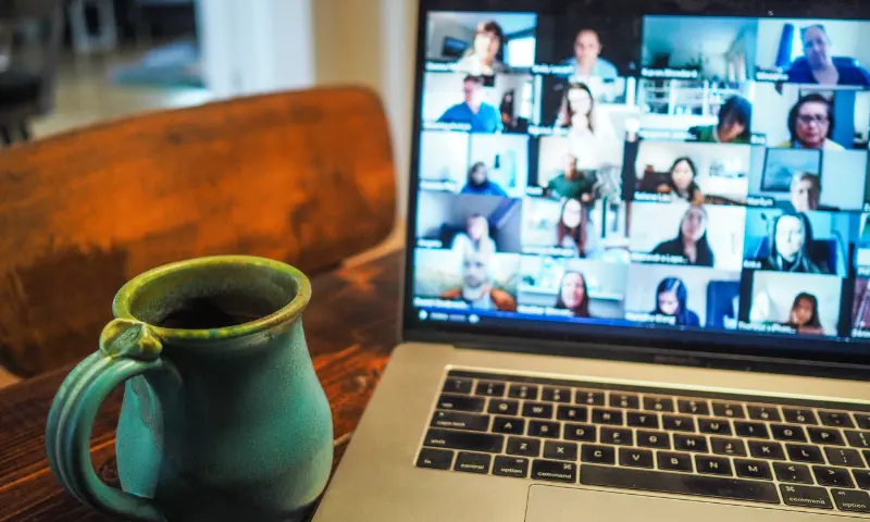 A laptop showing a zoom video conference on its screen