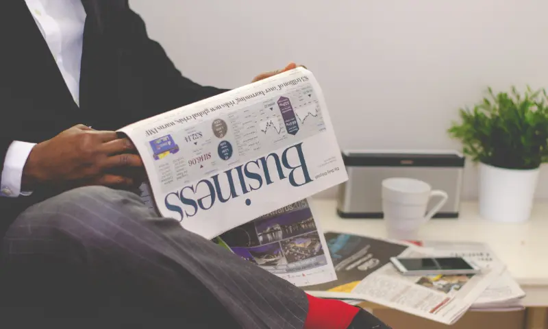 Someone reading the business section of a newspaper